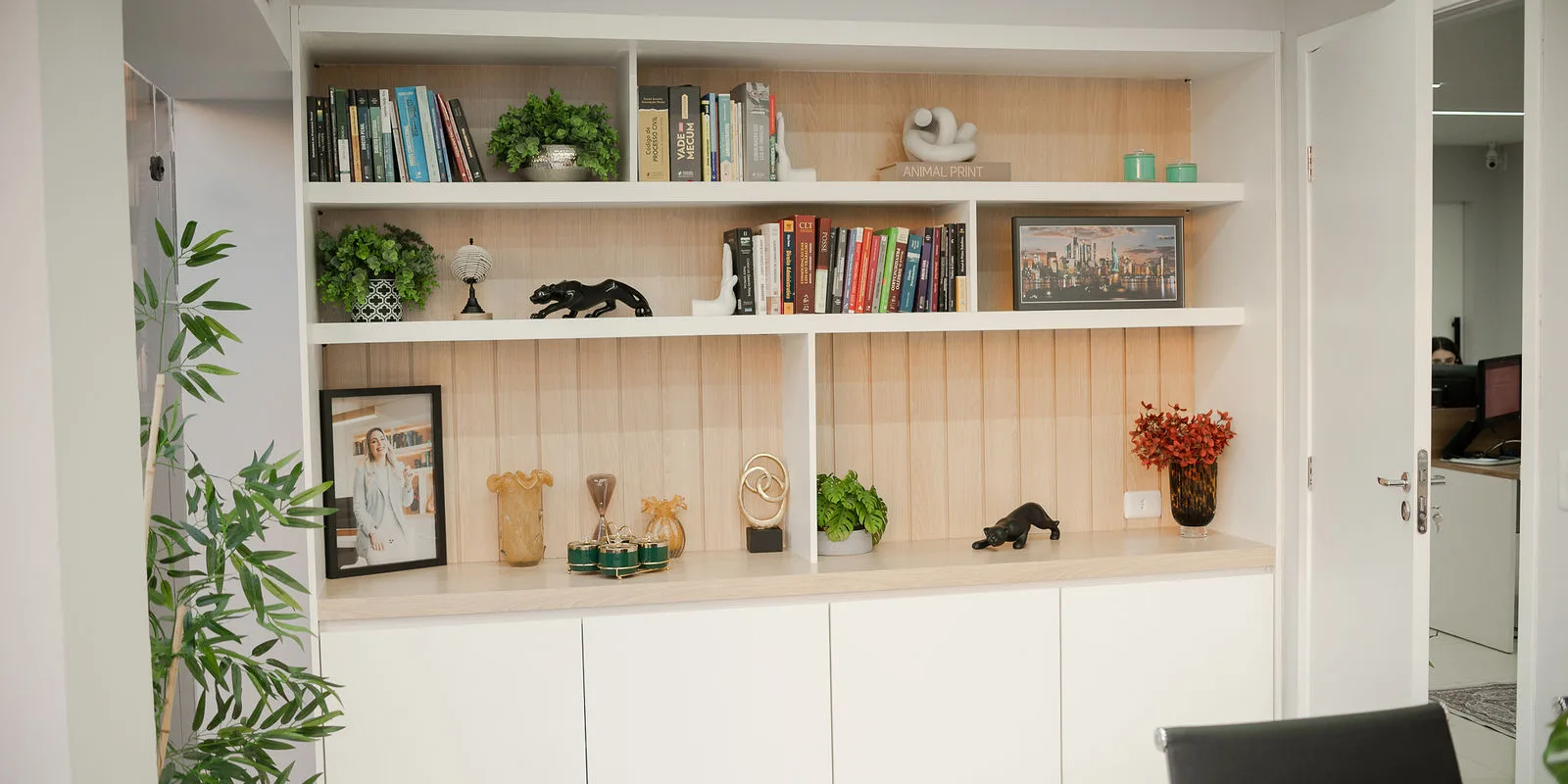 Estantes de uma das salas do escritório, com livros e objetos de decoração